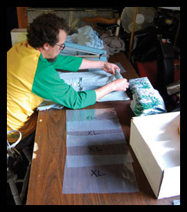 RISE Designs - Mike, folding and bagging some shirts.
